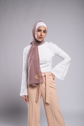 light skinned Hijabi girl in EMMA Scarf Dazzle In Mauve with an embroidered sequin flower and diamond on it on a chiffon mauve hijab