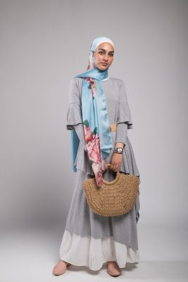 Hijabi Model in EMMA Scarf Aqua Fleuri staring at camera holding a beach bag
