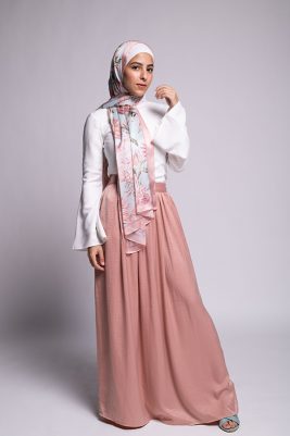 Hijabi Model in EMMA scarf Honey Blooms satin, a print of bees and delicate pink flowers with a pink border.looking at camera