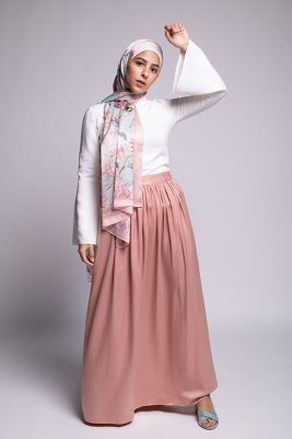 Hijabi Model in EMMA scarf Honey Blooms satin, a print of bees and delicate pink flowers with a pink border. In a pink skirt