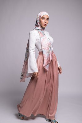 Hijabi Model in EMMA scarf Honey Blooms satin, a print of bees and delicate pink flowers with a pink border.looking at camera