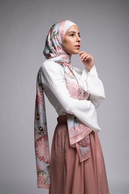 Hijabi Model in EMMA scarf Honey Blooms satin, a print of bees and delicate pink flowers with a pink border.